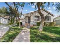 Charming single-story home featuring a well-maintained lawn, mature trees, and a welcoming front entrance at 2626 E Valencia St, Gilbert, AZ 85296