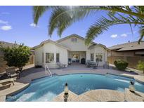 Inviting backyard featuring a refreshing pool, covered patio, and ample space for outdoor activities at 40830 W Bedford Dr, Maricopa, AZ 85138