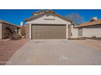 A house featuring a two-car garage, desert landscaping, and a light stucco exterior at 8772 W Grovers W Ave, Peoria, AZ 85382