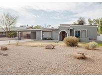 View of a single story home with unique desert landscaping and covered parking at 1111 E Village Circle N Dr, Phoenix, AZ 85022