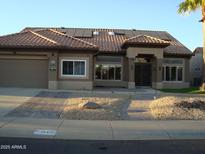 Charming single-story home with a tile roof, solar panels, desert landscaping, and a two-car garage at 14432 W Robertson Dr, Sun City West, AZ 85375