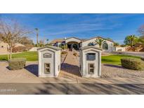 Charming home showcasing a brick walkway, lush green lawn, and distinctive mailbox structures in a well-manicured yard at 19864 E Via Del Oro --, Queen Creek, AZ 85142