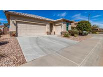 Charming home featuring a three-car garage, desert landscaping, and a stone-accented facade at 22754 W Moonlight Path, Buckeye, AZ 85326