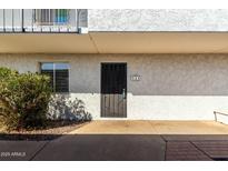 Exterior view of condo entrance with security door, small window, and manicured landscaping at 3313 N 68Th St # 111, Scottsdale, AZ 85251