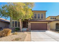 Two-story home showcasing neutral stucco, a brown garage door, and a manicured desert landscape at 33731 N Slate Creek Dr, San Tan Valley, AZ 85143