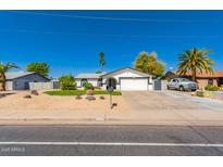 Charming single-story home with desert landscaping, mature trees, and an attached two-car garage at 4154 W Grovers Ave, Glendale, AZ 85308