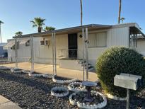 Charming manufactured home featuring a covered porch with decorative landscaping and palm trees in the community at 9501 E Broadway Rd # 71, Mesa, AZ 85208