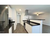 Modern kitchen featuring stainless steel appliances, white cabinets and a breakfast bar at 10562 W Campana Dr, Sun City, AZ 85351