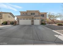 Charming two-story home with stone accents, a three-car garage, and a well-manicured front yard at 21613 N Sunset Dr, Maricopa, AZ 85139