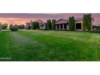Expansive front yard with manicured lawn and mature landscaping at dusk at 21962 E Diana Way, Queen Creek, AZ 85142