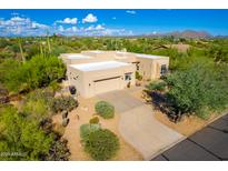 Desert home showcasing a native landscaped yard with a private driveway and a two-car garage at 27467 N 75Th Way, Scottsdale, AZ 85266
