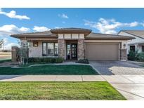 Charming single-story home featuring a manicured lawn, brick accents, and a two-car garage at 3947 E Austin Dr, Gilbert, AZ 85296