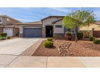Charming single-story home featuring desert landscaping, a two-car garage, and stone accents at 4960 S Wade Dr, Gilbert, AZ 85298