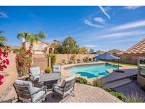 Inviting backyard features a sparkling pool, lounge chairs, and outdoor seating, perfect for relaxing and entertaining at 10490 E Dreyfus E Ave, Scottsdale, AZ 85260