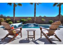 Inviting backyard pool area with waterfall feature and comfortable lounge chairs, perfect for relaxing and entertaining outdoors at 21857 N Gibson Dr, Maricopa, AZ 85139