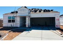New construction home featuring open garage, paved driveway, and roof tiles ready for installation at 28200 N Nealite Dr, San Tan Valley, AZ 85143