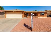 Inviting single-story home featuring a well-maintained brick exterior, a two-car garage, and desert landscaping at 8118 E Medina Ave, Mesa, AZ 85209