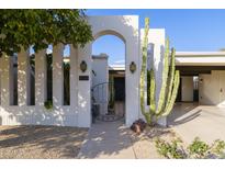 Stunning arched gate with a private entrance to the home, complemented by desert landscaping and unique lighting fixtures at 8720 E Via De Dorado --, Scottsdale, AZ 85258