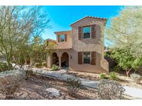 Two-story home with a front yard, desert landscaping, and brown shutters at 10054 E Bell Rd, Scottsdale, AZ 85260