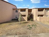 Two-story condo building showcasing a common walkway and front lawn on a sunny day at 1942 S Emerson -- # 217, Mesa, AZ 85210