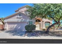 Charming two-story home with manicured lawn, mature tree, and two car garage at 1980 N Santa Fe Ct, Casa Grande, AZ 85122