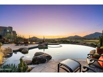 Relaxing backyard pool with a stunning desert view as the sun sets on the horizon at 40947 N 107Th Pl, Scottsdale, AZ 85262