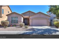 Charming single-story home featuring a well-maintained yard with desert landscaping and a two car garage at 42297 W Lunar St, Maricopa, AZ 85138