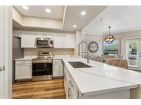 Modern kitchen featuring white cabinets, stainless steel appliances, and a spacious countertop island at 15095 N Thompson Peak Pkwy # 1053, Scottsdale, AZ 85260