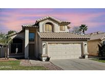 Charming two-story home featuring a desert landscape, tile roof, and a two-car garage at 1698 E Barbarita Ave, Gilbert, AZ 85234