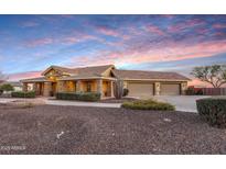 Lovely home featuring a long driveway, three car garage, and desert landscaping at 18919 W Verde Ln, Litchfield Park, AZ 85340