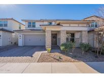 Charming two-story home featuring stone accents, a paved driveway, and a well-manicured front yard, offering classic curb appeal at 20947 E Mayberry Rd, Queen Creek, AZ 85142