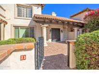 Inviting front entrance featuring a charming brick path, stucco walls, and wrought iron details at 6701 N Scottsdale Rd # 23, Scottsdale, AZ 85250