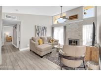 Bright living room features a modern fireplace, neutral decor, and wood-look tile floors at 930 S Dobson Rd # 41, Mesa, AZ 85202