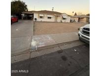 Classic single-story home featuring neutral siding, minimal landscaping, and a covered carport at 110 E Franklin Ave, Mesa, AZ 85210