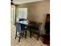 A cozy dining area features a table with seating for three and bright natural light from a window at 1621 N 38Th Dr, Phoenix, AZ 85009