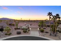 Stunning single-Gathering home with desert landscaping, tile roof, and attached two-car garage at sunset at 16464 W Una Noche Ct, Surprise, AZ 85374