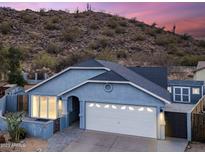 Charming single-story home with a two-car garage and desert landscaping, nestled against a picturesque hillside backdrop at 1723 E Behrend Dr, Phoenix, AZ 85024