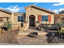 Inviting front exterior with desert landscaping, brick pathway, and charming decorative iron door at 20391 N Sunrise Ln, Maricopa, AZ 85138