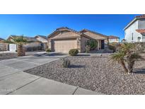 Charming single-story home with a well-manicured gravel yard, palm trees, and a two-car garage at 214 N 222Nd Dr, Buckeye, AZ 85326