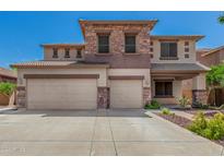 A two-story home with a three-car garage and a stone-accented facade, under a clear blue sky at 4245 S 247Th Dr, Buckeye, AZ 85326