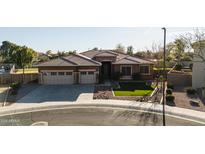 Beautiful home with a well-maintained front yard, a two-car garage, and a decorative tile roof at 4702 N 151St Dr, Goodyear, AZ 85395