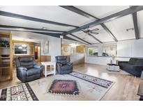 Open-concept living room with wood floors, beamed ceilings, and comfortable seating at 8103 E Southern Ave # 25, Mesa, AZ 85209