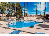 Community pool with sun loungers, tables, and well-maintained landscaping around the pool area at 8231 N 21St Dr # E101, Phoenix, AZ 85021