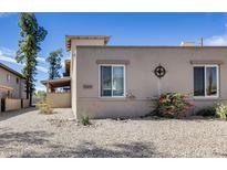 Tan home exterior featuring desert landscaping, two windows, and a decorative metal accent under a clear, blue sky at 14644 N Yerba Buena Way # C, Fountain Hills, AZ 85268