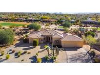 Desert home with tile roof, spacious three car garage, and desert landscaping including native cactus and beautiful plants at 18419 E Agua Verde Dr, Rio Verde, AZ 85263