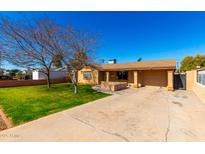 Charming single-story home with well-manicured lawn and driveway, under a clear blue sky at 1926 E Clarendon Ave, Phoenix, AZ 85016
