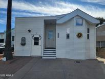 Charming home featuring a covered entry, white siding, tasteful accents, and a well-manicured front yard at 2260 S Seminole Dr, Apache Junction, AZ 85119