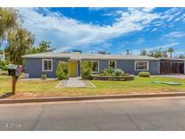 Charming home featuring a yellow door and a well-maintained front yard with mature landscaping at 2441 E Edgemont Ave, Phoenix, AZ 85008