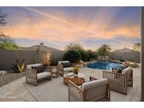 Relaxing backyard with a private pool, waterfall feature, and outdoor seating for entertaining at 7111 E Sienna Bouquet Pl, Scottsdale, AZ 85266