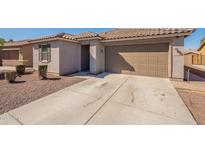 Tan single-Gathering home showcasing a two-car garage, desert landscaping, and a durable tile roof at 7552 W Darrel Rd, Laveen, AZ 85339